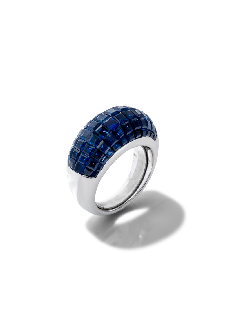 A silver ring featuring a textured, grid-like bezel setting of deep blue gemstones, on a clean white background with a soft shadow.